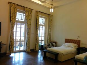 加尔各答哈灵顿住宿加早餐旅馆的一间卧室设有一张床和一个大窗户