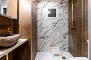 巴达洛纳Apartamento en planta baja en badalona, barcelona的一间带水槽和大理石墙的浴室