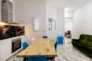 巴达洛纳Apartamento en Planta Baja en Badalona的客厅配有木桌和蓝色椅子