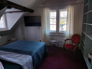施莱登Alte Rentei的一间卧室配有一张床、一把椅子和窗户。