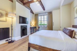 伦敦Oak & Poppy的卧室配有一张白色大床和壁炉