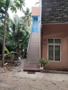蓬蒂切里Sri Sai Farm House的通往棕榈树房屋的楼梯