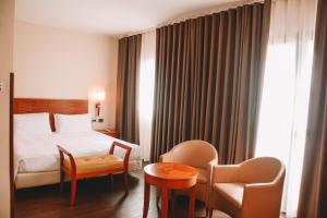 卡塞塔Hotel dei Cavalieri Caserta - La Reggia的配有床、椅子和桌子的酒店客房