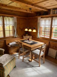 PeistBambi Lodge Ferienwohnung auf knapp 1400 m nahe Arosa的一间带木桌和椅子的用餐室