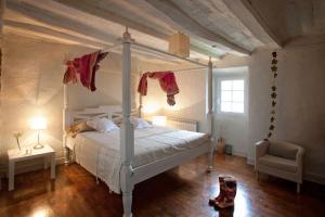 OlloHotel El Secreto de Ollo的卧室配有白色的天蓬床和椅子