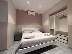 圣雷莫A Due Passi - Sanremo Apartments的一间卧室配有一张床,上面有两条毛巾