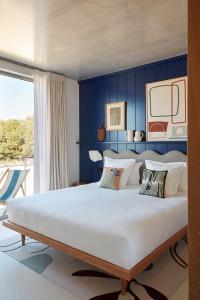 比亚里茨Hôtel de La Plage的一间卧室设有一张蓝色墙壁的大床