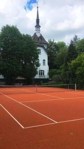 埃内佩塔尔Luxus Villa EMG Dortmund nah Düsseldorf, Köln, Essen的一座网球场,其建筑背景为: