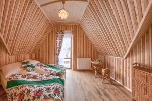 BańskaGÓRALOWE domki & SPA的一间带两张床铺的卧室,位于带木墙的房间内