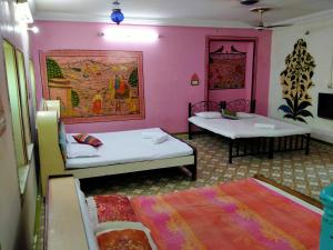 焦特布尔Golden Dreams Guest House的配有粉红色墙壁的客房内的两张床