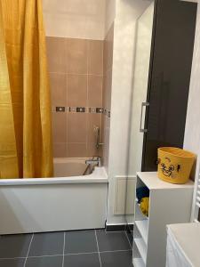 尚特洛普恩布里Welcome to Hakuna matata !的浴室配有浴缸、淋浴和黄色的浴帘