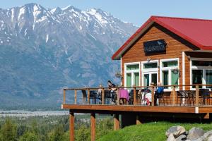 帕尔默Alaska Glacier Lodge的一群人坐在房子的阳台上