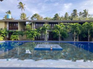 米瑞莎Handagedara Resort & Spa的一座带度假村的建筑前的游泳池