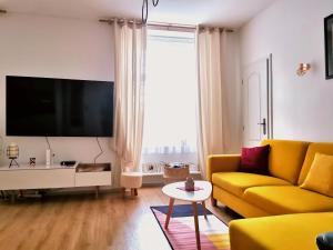 布拉迪斯拉发CozyHome The Castle Apartment - Spacious, quiet, high ceiling的客厅配有黄色沙发和平面电视。