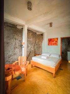 圣马科斯拉拉古纳Lush Atitlán的一间卧室配有一张床和两张木椅