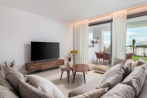 马贝拉Exclusive New Apartment within Santa Clara and Marbella Golf & Country Club的带沙发和平面电视的客厅