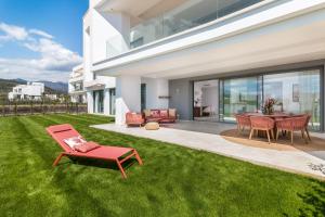马贝拉Exclusive New Apartment within Santa Clara and Marbella Golf & Country Club的一个带红色椅子和桌子的院子