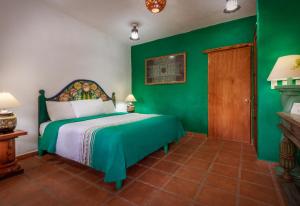 帕茨库卡罗利克希生态酒店的一间带绿色墙壁和床的卧室