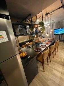 里约热内卢Flat Moderno e decorado Lapa-RJ的厨房以及带桌子和冰箱的用餐室