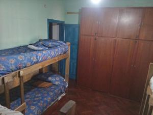 卢汉德库约HOSTEL ATG的一间卧室设有两张双层床和木制橱柜。