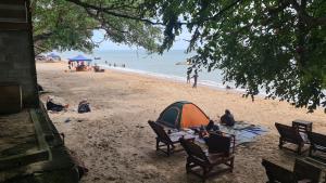 彭佳兰巴拉海滩Kampong Style Homestay Pengkalan Balak - Sea View的一群人坐在海滩上,带帐篷