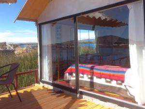 普诺Uros Titicaca Khantaniwa Lodge的客房设有阳台,在甲板上配有一张床