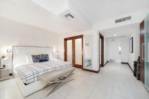 迈阿密海滩Strand Ocean Drive Suites的白色卧室配有床和镜子