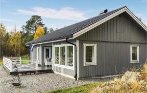 胡迪克斯瓦尔Gorgeous Home In Hudiksvall With Wifi的一间灰色的小房子,设有门廊和窗户