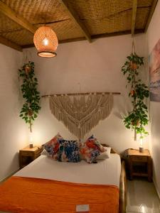 圣玛尔塔Ritacuba House Boutique的卧室配有一张床,墙上挂有两株植物