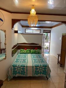 乌图罗阿Bellevue Raiatea的一间卧室配有一张床和一个吊灯