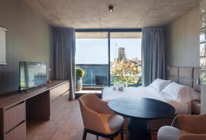 布宜诺斯艾利斯Live Soho Boutique & Apartments Palermo Soho的酒店客房设有一张床和一个大窗户