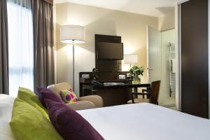 巴黎馨乐庭巴黎共和酒店的配有一张床和一张书桌的酒店客房