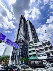 吉隆坡Continew Residences TRX Lux Pool View的前面有路标的高楼