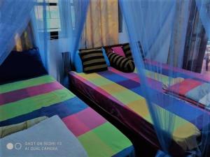 埃拉艾拉隧道角落宾馆的一间卧室配有一张色彩缤纷的床和窗户