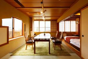 下吕市水凤园日式旅馆的一间带桌椅和一张床的用餐室