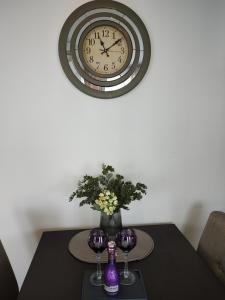 弗尔尼亚奇卡矿泉镇Apartman Gala的一张桌子,上面有时钟和花瓶