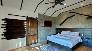 阁遥岛Rongna Villas的一间卧室配有一张床和吊扇