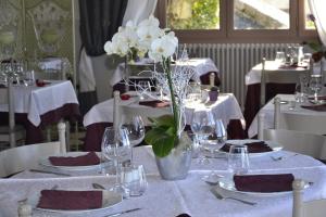 Rians海滨大道好客酒店的白板和玻璃杯的桌子,花瓶,白色花