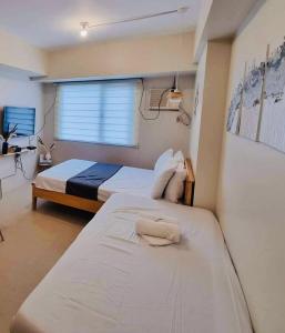 大雅台Nordic Bleu Staycation at Ayala Serin的一间卧室设有两张床和窗户。