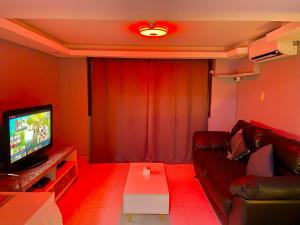 CaintaIV’s Condo w/ Netflix, Wifi & Karaoke的带沙发和电视的客厅