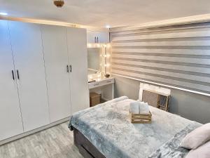 CaintaIV’s Condo w/ Netflix, Wifi & Karaoke的卧室配有白色橱柜、床和水槽。