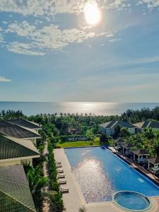 洞海黄金海岸Spa度假酒店 的享有度假村游泳池和海洋的空中景致