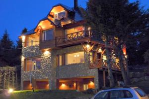 圣卡洛斯-德巴里洛切El Nautico Lodge Bariloche的前面有一辆汽车停放的大房子