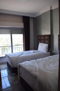 亚喀巴Baron Palace hotel suites的酒店客房设有两张床和一个阳台。