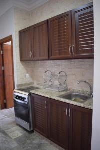 亚喀巴Baron Palace hotel suites的一个带木制橱柜和水槽的厨房