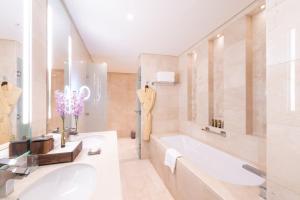 多哈Shaza Doha的白色的浴室设有浴缸和水槽。