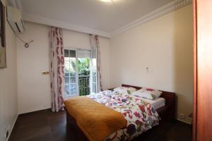 雅温得Residence MASSOU的一间卧室设有一张床和一个窗口