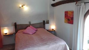 Margarida磨坊乡村酒店及餐厅的一间卧室配有一张带粉红色枕头的床