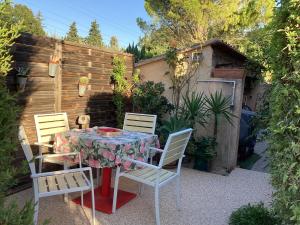 格拉沃松Studio en Provence avec piscine的后院设有围栏,配有桌椅