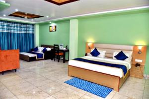 帕拉姆普尔Jai Hotel By Boho的一间卧室配有一张床、一张沙发和一张书桌